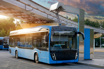 Fototapeta premium Bus at a charging station has its pantograph connected to a high voltage connector at the final stop of the route.