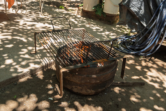 Parrilla calent&aacute;ndose con brasas y humo antes del asado argentino de fin de semana