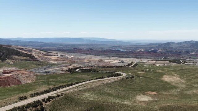 Wide aerial of mining operations and highway in Vernal Utah in spring