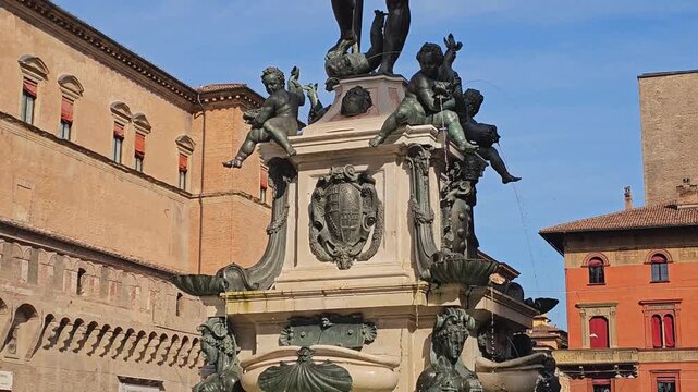 Architectural detail of the Fountain of Neptune in Bologna, Emilia-Romagna, Italy, with decorative sculpture and historic buildings.