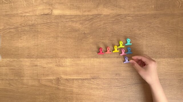 Child's Hand Placing a Purple Paper Clip in an Organized Row, 4K Slow Motion