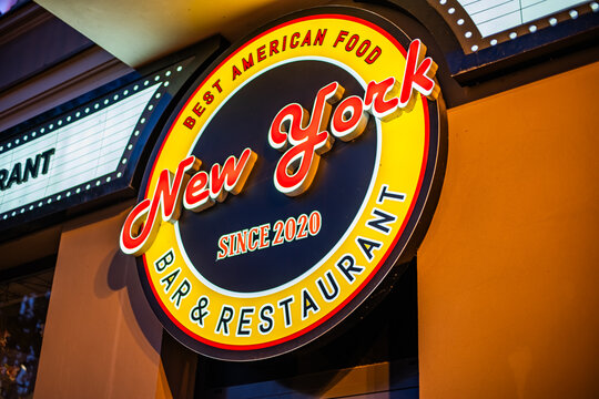 Gniezno, Poland - 22 April 2026: Illuminated circular New York Bar and Restaurant sign glowing at night, advertising best American food since 2020