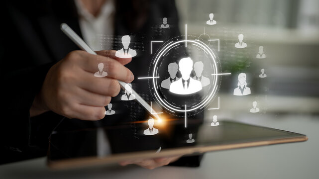 Business professional using tablet to select user profiles with digital icons and target graphics in modern office setting Sigmoid