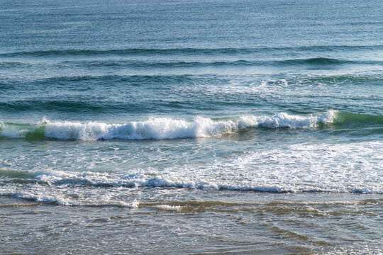 Close up of ocean wave splashing on sandy shore