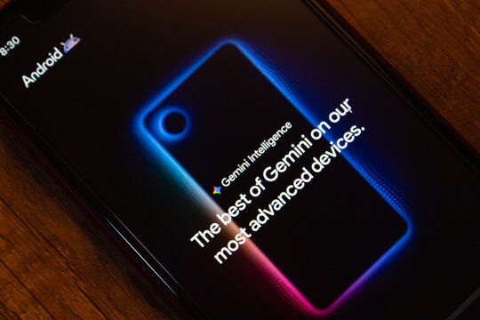 Mexico City, MEXICO - May 18 2026 : Phone screen showing Google Gemini Intelligence text and glowing device graphic on a wooden table.