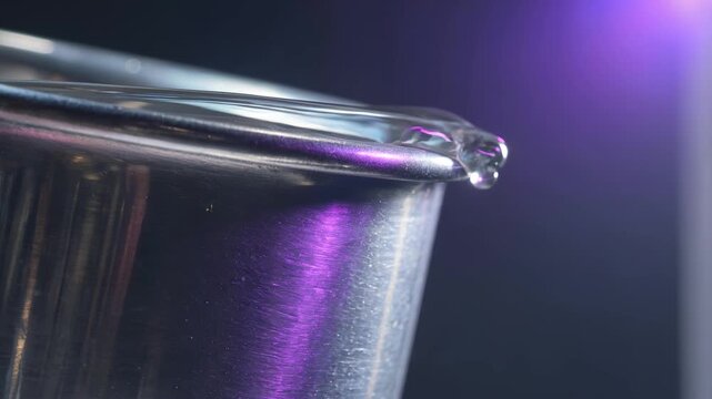 Superfluid helium Onnes effect creeping over titanium beaker lip inside cryogenic chamber with zero viscosity quantum liquid detail