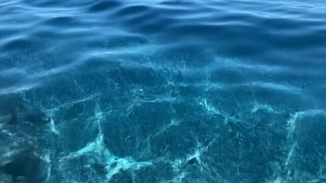 Deep blue ocean water with sunlight patterns on surface