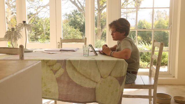 12 year old boy eating lunch and using smart phone at home