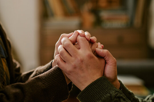 Close up of young adult couple holding hands, expressing support during financial hardship and emotional stress. Ideal for poverty, crisis, empathy, counseling, or aid campaigns