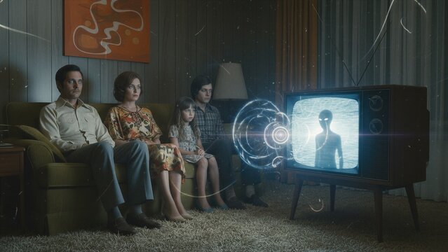 Family watching alien on vintage television set. Man, woman, boy and girl sitting on couch mesmerized by extraterrestrial transmission. Science fiction paranormal broadcast in living room.