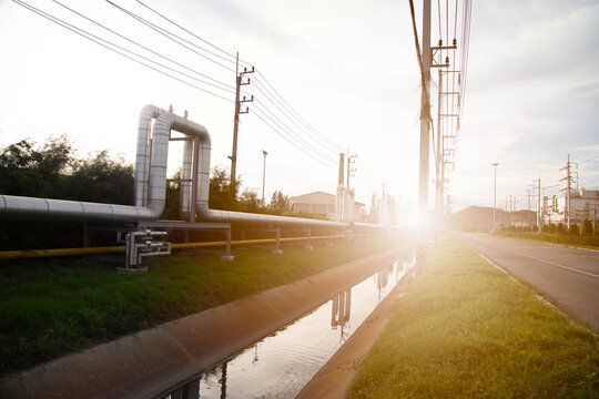 Large insulated steel pipelines for oil, gas or steam distribution with power poles.