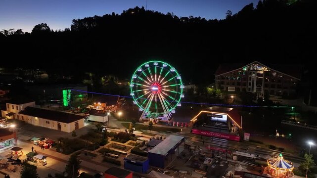 Night View Of Capivari Village In Campos Do Jordao In Sao Paulo Brazil. Illuminated Ferris Wheel. Downtown Cityscape. European Architecture. Capivari Village In Campos Do Jordao In Sao Paulo Brazil. 