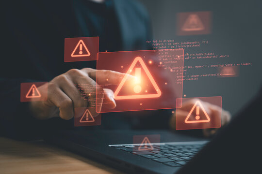 Cybersecurity warning concept with businessman using laptop and digital alert icons. Symbol of system error, cyber attack, malware detection, data breach and online security risk.