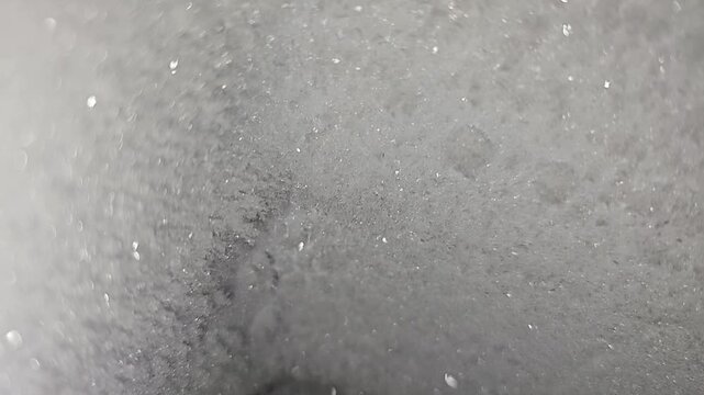 Close-up abstract macro footage featuring a dark frosted surface with subtle sparkling highlights and soft cinematic focus. Ideal for background overlays, moody edits, sci-fi visuals, title sequences,