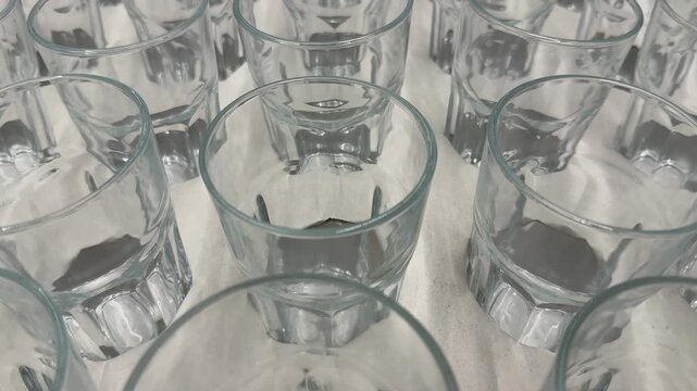 Row of clear glass tumblers arranged on a white table surface
