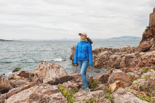 Adventure woman standing on rocky coastline