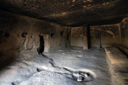 Interior view of a historic rock-cut cave room carved into volcanic tuff in G&ouml;reme, Cappadocia, T&uuml;rkiye.