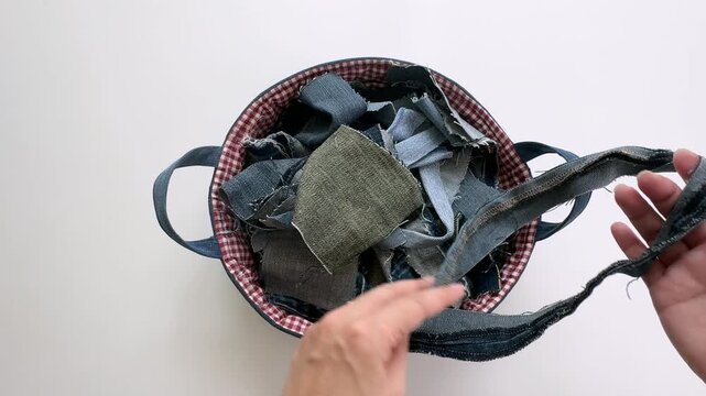 Hands Holding Upcycled Denim Fabric Strips in Handmade Sewing Basket
