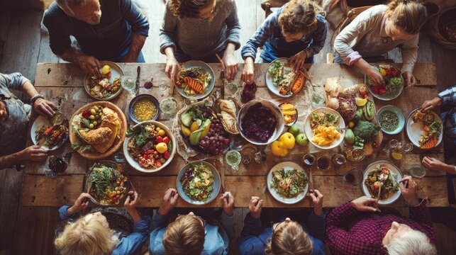 Overhead shot of extended family sharing dinner at long wooden table, diverse ages and cultures, vibrant healthy food, warm indoor lighting, editorial style realism