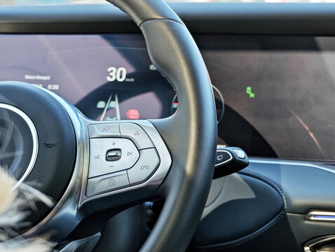 Modern car interior showcasing the multi-function steering wheel and a digital dashboard with an active driver-assistance system. Concept for autonomous driving