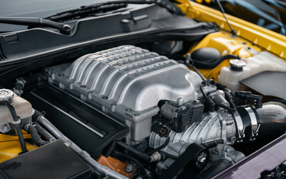 Supercharged engine close up. Powerful american V8 engine with forced induction - eight cylinder powerplant with aluminium supercharger bolted on top of.