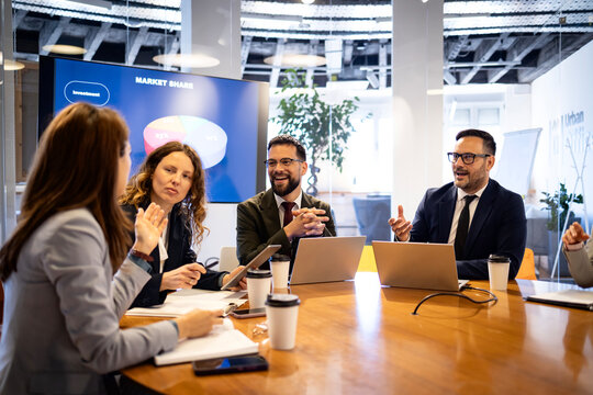 Business professionals collaborating in a modern office, discussing market share data during a corporate meeting