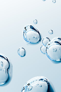 Transparent blue cosmetic bubbles with glossy liquid texture on soft background. Abstract water serum gel for skincare, beauty, hydration, collagen, hyaluronic acid and wellness concepts.