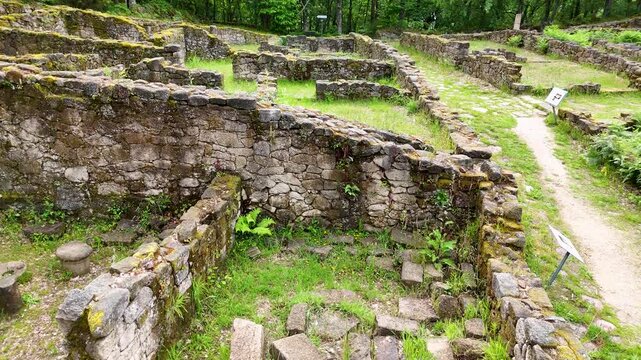 Aerial view of the ancient stone ruins of Castro de Armea surrounded by lush green vegetation and forest in Allariz, Province of Ourense, Spain.