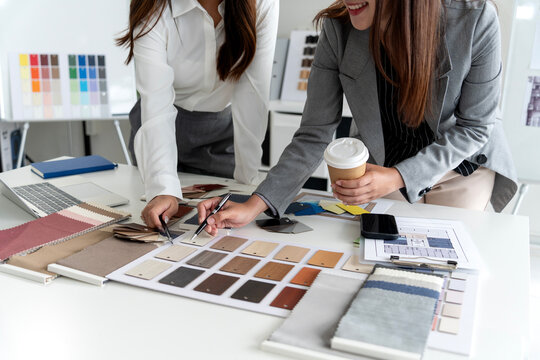 Interior Designer Selecting Material Samples and Color Swatches with Client in Studio