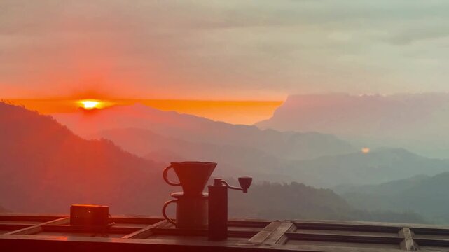 A balcony view with drip coffee equipment on a sunrise over the mountain in Chiang Mai, Thailand.