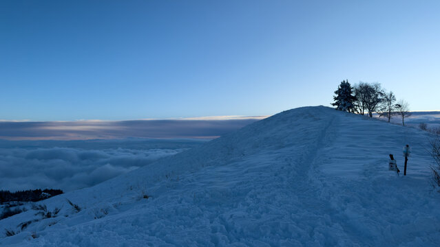 on the snow-capped peak of Mount Mottarone, Clouds moving in the valley at sunset.