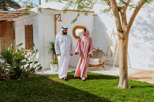 Emirati couple walking through a traditional garden together