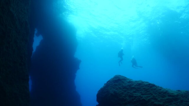 t the end of dive scuba divers coming back up to the surface to get on the boat underwater