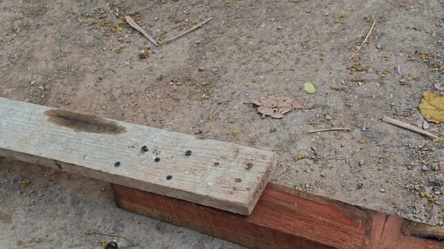 Gloved hands aligning and joining wood planks on the ground workshop