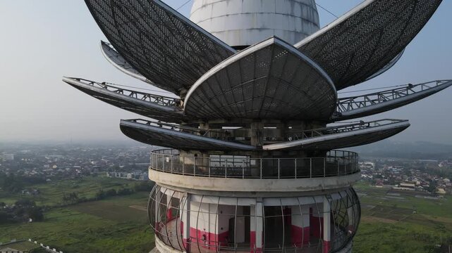 Aerial view of Menara Pandang Teratai with its lotus-shaped metallic petals overlooking the urban landscape in Kecamatan Purwokerto Timur, Jawa Tengah, Indonesia.