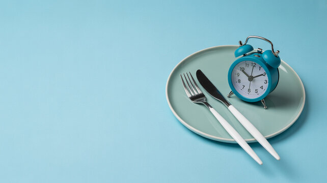Alarm clock with fork and knife on a plate