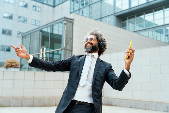 Young entrepreneur business man listening to music and dance
