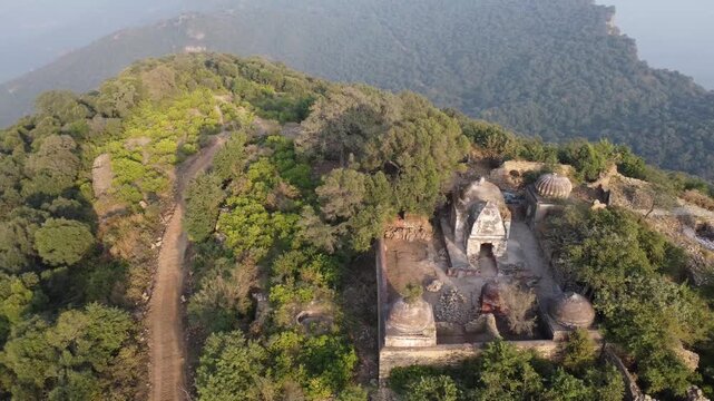 Tilla jogian sikh shrine with domed roofs on forested hilltop in punjab pakistan