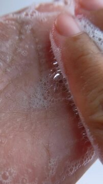 Rubbing hand soap foam up close slowly, maintaining cleanliness, skin care concept
