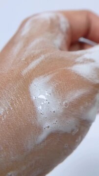 Showing palm of hand that has been soaped. Vertical close up view. Bathing and maintaining hygiene concept. Clean skin with soap bubbles.