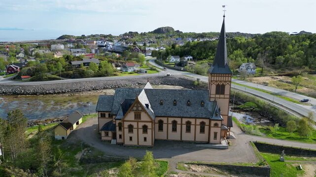 Picturesque aerial view orbiting the historical Vagan Church, known as Lofoten Cathedral, situated in the charming coastal town of Kabelvag