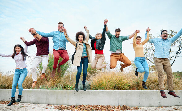 Group of young happy people or students having fun together outdoors in street or park or outside the university college or school. Happy friendship concept with young people having fun together. Youn