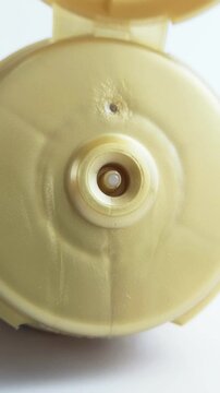 Front view of white beauty cream coming out from product packaging. Vertical close up capture. Skincare concept for skin treatment and daily care.