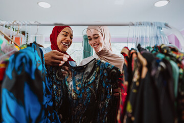 Obraz premium women friends smiling shopping in clothing store