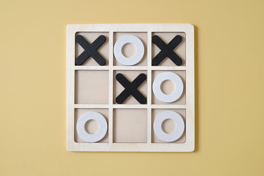 OX Wood Board Game or Tic tac toe set on color background.