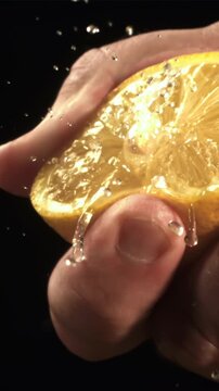 Hand squeezes lemon juice with splashes. Filmed on a high-speed camera at 1000 fps. High quality FullHD footage