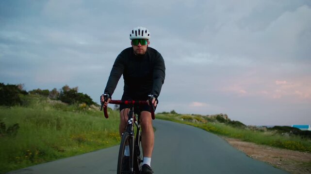 Cycling in nature. A cyclist rides a bike on a beautiful asphalt road.