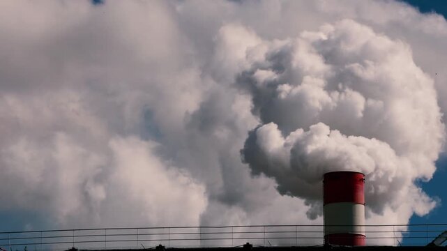 Industrial factory chimney emitting white smoke into the sky