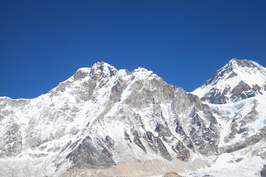 Everest base camp in off-season on the everest base trek, empty of tents and climbers, beneath himalayan peaks under a blue sky