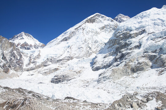 Everest base camp in off-season on the everest base trek, empty of tents and climbers, beneath himalayan peaks under a blue sky